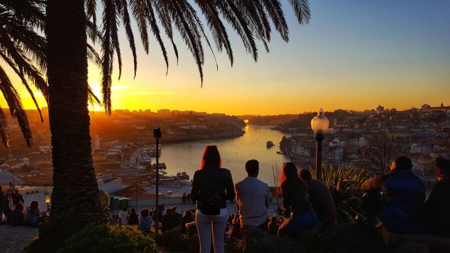 Porto: Tuk Tuk Sunset Tour with Glass of Port Wine - Porto at sunset, with the city moving around you